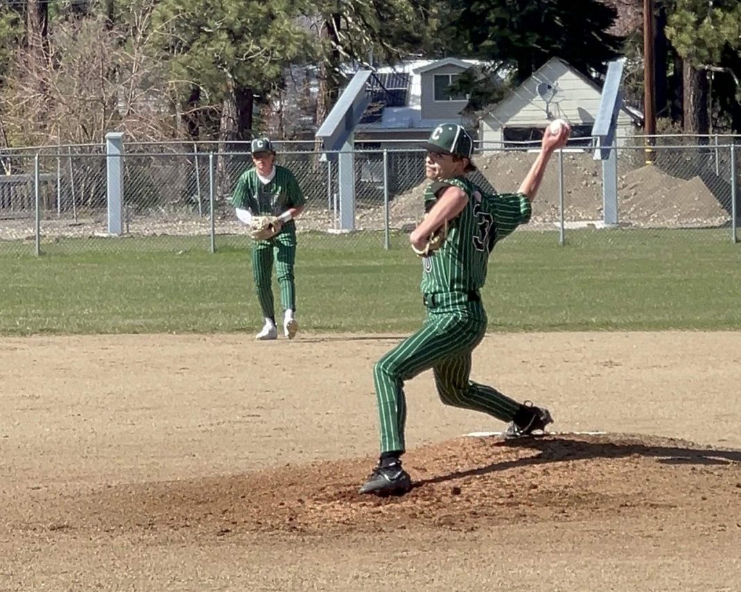 Caiden Clark pitches for the Chester Volcanoes against Burney April 19, with Jax Holland at shortstop in the background. Photo by Kim Clark